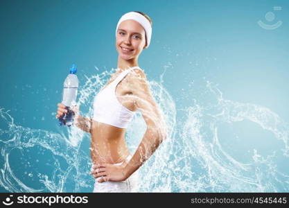 Sport woman and pure water. Young pretty woman in sport wear holding a bottle with pure water