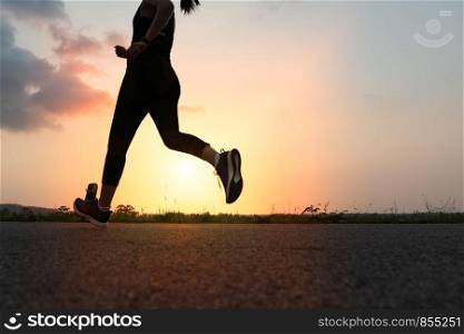 sport woman running on a road. Fitness woman training at sunset
