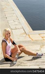 Sport woman slim body relax sitting stone ground summer day