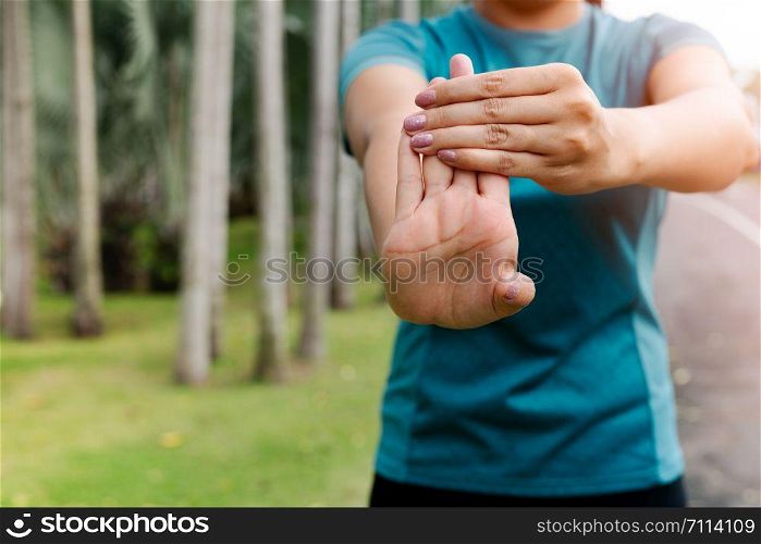 sport woman stretching forearm before exercising. outdoor sport and excercise activities concept