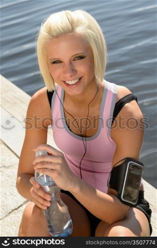 Sport young woman relax sitting by water pier sunny day