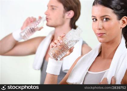 sportive duo drinking water