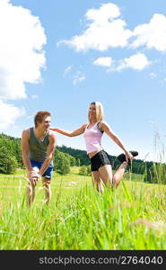 Sportive happy couple in countryside meadows blue summer sky