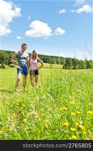 Sportive happy couple in countryside meadows blue summer sky