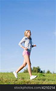 Sportive jogging young happy woman meadows blue summer sky