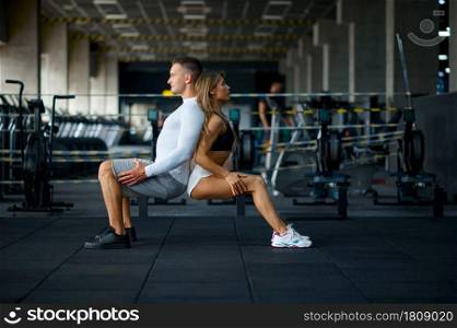 Sportive love couple doing endurance exercise, training in gym. Athletic man and woman on workout in sport club, active healthy lifestyle, physical wellness. Couple doing endurance exercise, training in gym