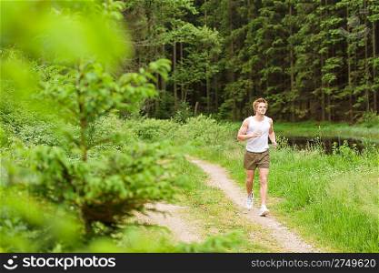 Sportive man jogging in nature by lake in sportive outfit