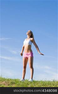 Sportive stretching young happy woman meadows blue summer sky
