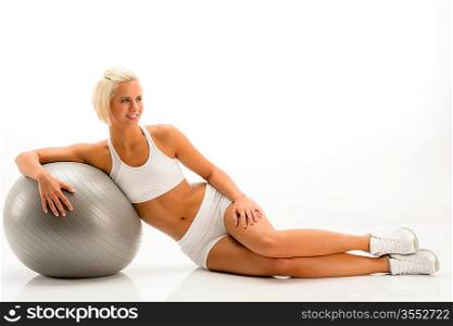 Sportive woman leaning on gym ball on white background