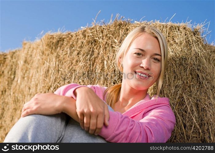 Sportive young woman relax lean against hay bales sunset countryside