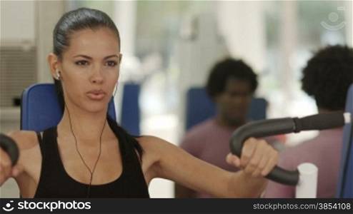 Sports activity, young man and woman exercising and working out in wellness gym. Rack focus