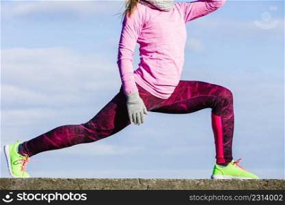 Sports and activities concept. Slim fit attractive woman exercising stretching outdoor. Young motivated girl training in sporty clothes