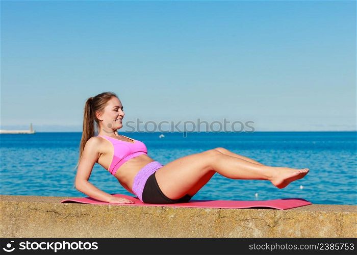 Sports and activities concept. Slim fit attractive woman exercising stretching outdoor. Young motivated girl training in sporty clothes.. Young woman exercising outside