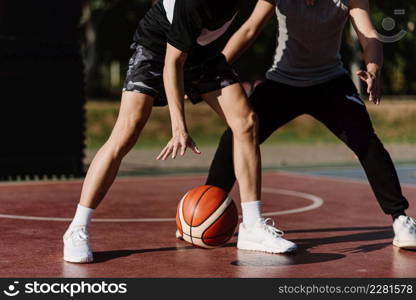 Sports and recreation concept two male basketball players enjoying playing basketball together on the sports ground.