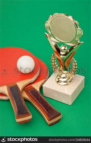 sports awards and tennis racquets on a green table