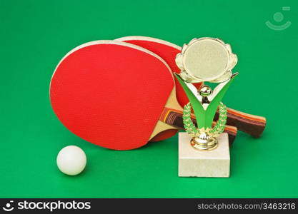 sports awards and tennis racquets on a green table