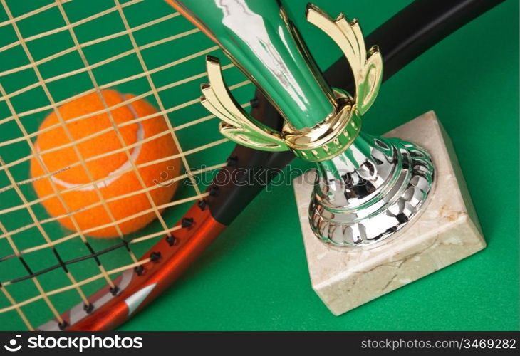 sports awards and tennis racquets on a green table