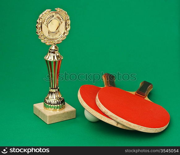 sports awards and tennis racquets on a green table