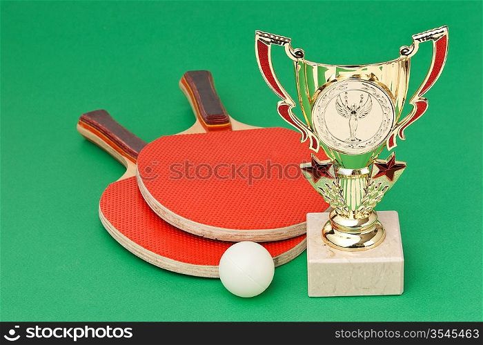sports awards and tennis racquets on a green table