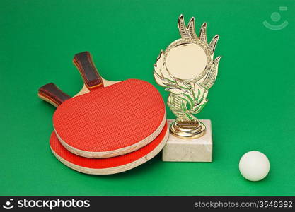 sports awards and tennis racquets on a green table