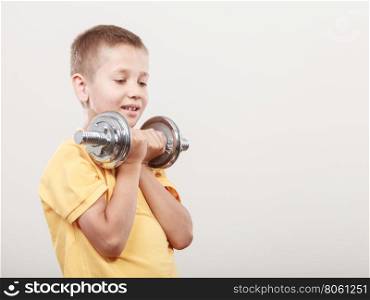 Sports boy making exercise with heavy dumbbell. Care about health and body