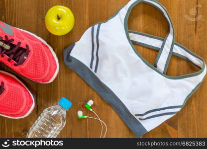 sports bra and sneakers for fitness a top view of the wooden floor