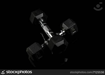 sports dumbbells with black rubber handle on black isolated background