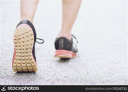 Sportsman foot runner trail running outdoors. close up on shoe behind of a man running fitness jogging workout uphill in autumn trail of nature and stones. exercise healthy lifestyle and sport concept