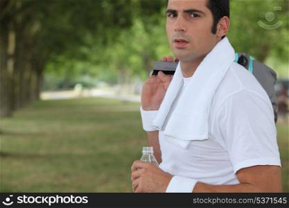 Sportsman in a park with a bottle of water