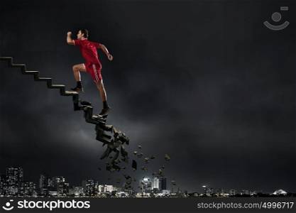 Sportsman overcoming challenges. Sports active man running on stone collapsing ladder