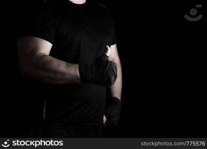 sportsman's hands wrapped in black elastic sports bandage show a like sign, dark background