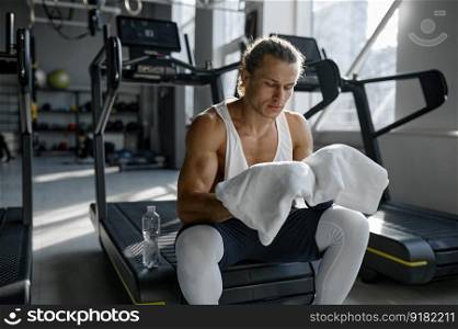 Sportsman with muscular body feeling tired and exhausted after treadmill training at gym. Cardio run workout concept. Sportsman with muscular body feeling exhausted after treadmill training