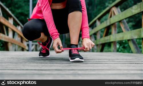 Sportswoman tying shoelace preparing to run outdoors