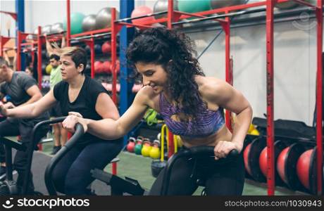 Sportswomen doing air bike at the gym. Sportswomen doing air bike indoor
