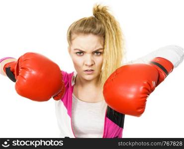 Sporty angry and agressive woman wearing red boxing gloves, fighting. Studio shot on white background.. Angry woman wearing boxing gloves
