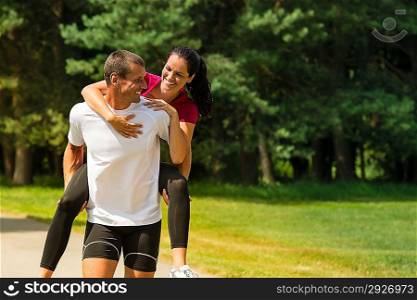 Sporty boyfriend giving piggyback ride to his girlfriend