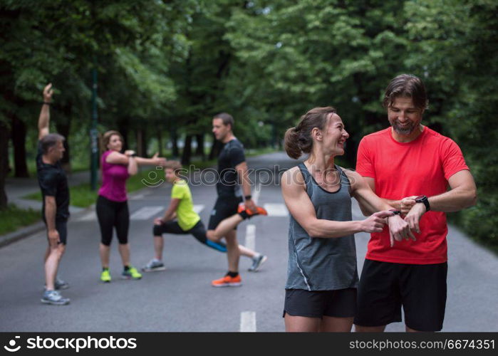 sporty couple using smart watches. Young sporty couple using smart watches starting their timer before jogging