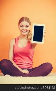 Sporty fitness girl holding tablet computer with blank screen showing copyspace. Happy smiling woman advertising new modern technology.. Sporty girl with pc tablet. Blank screen copyspace