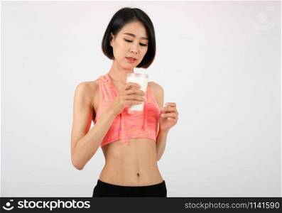 sporty fitness woman in sportswear drinking milk on white background. healthy sport lifestyle
