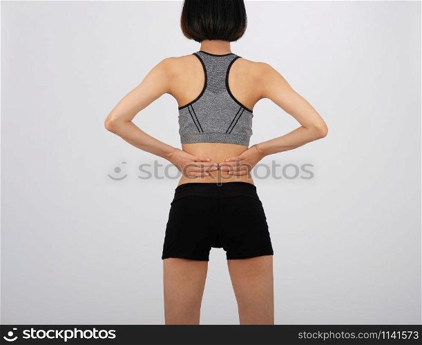 sporty fitness woman in sportswear with back pain on white background. sport injury