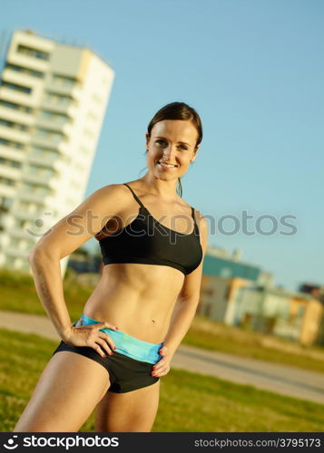 Sporty fitness woman in the park early in the morning, urban background