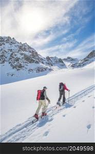 Sporty friends on ski mountaineering track uphill