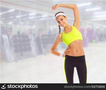 Sporty girl doing gymnastic exercises in fitness club