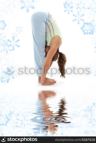 sporty girl practicing uttanasana standing forward bend on white sand