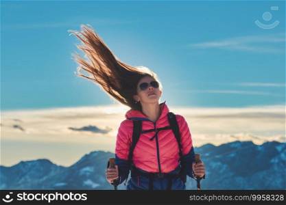 Sporty girl with hair blowing in the wind during mountain hike