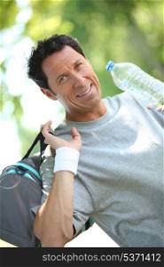 Sporty looking man drinking from a large bottle of water
