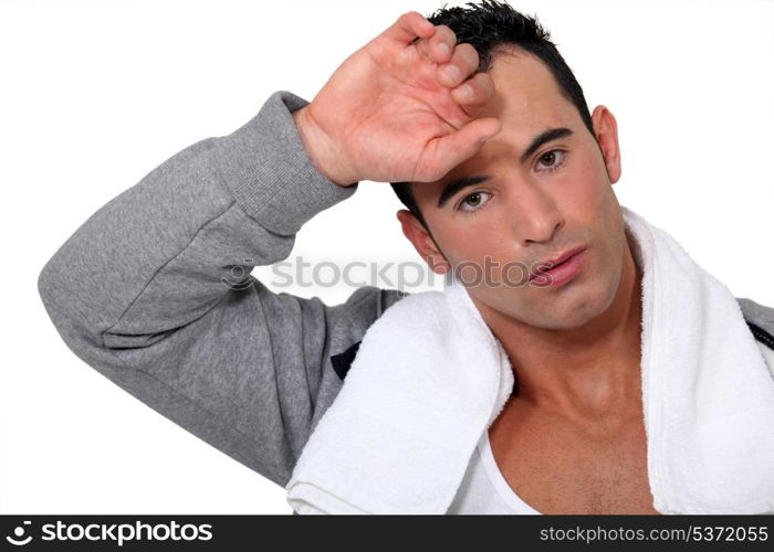 sporty man wiping sweat from forehead after effort