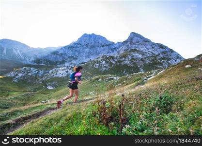 Sporty mountain woman rides in trail during endurance training