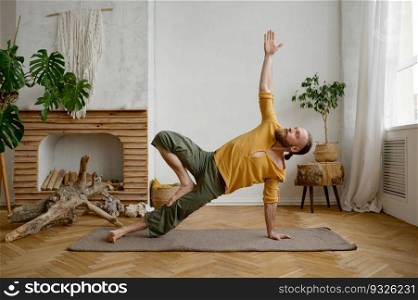 Sporty muscular man practicing hand standing yoga pose at home living room. High level fitness exercises. Man practicing hand standing yoga pose at home living room
