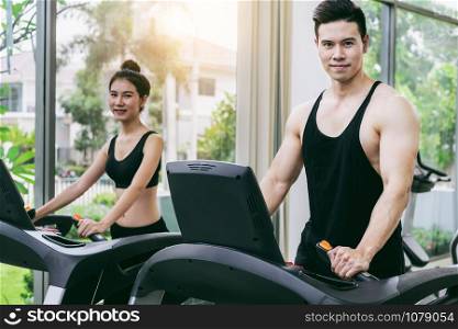 Sporty runner running on treadmill in fitness gym. Healthy lifestyle concept.